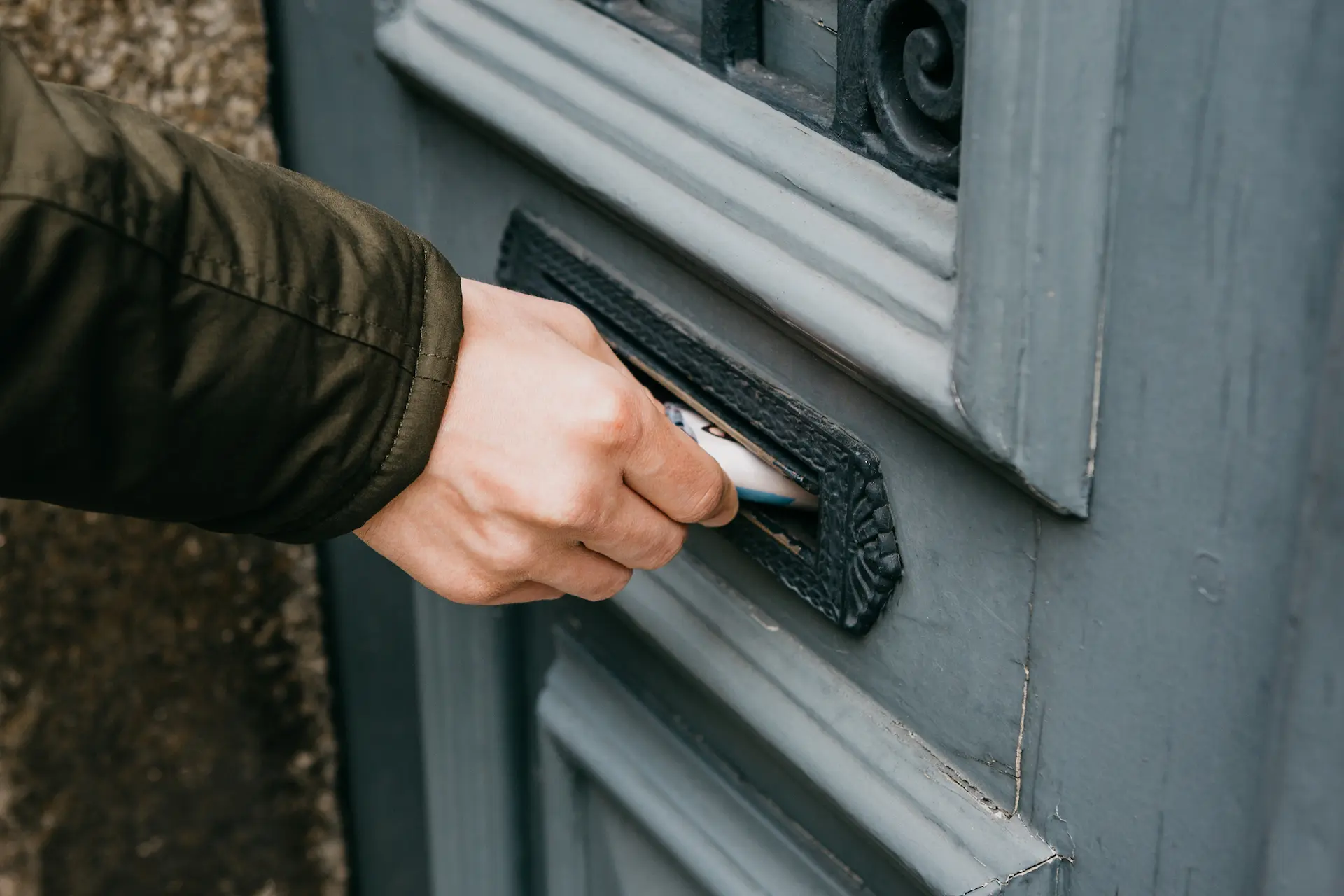 Man posting marketing materials through a letterbox